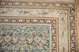 Distressed Malayer rug corner showcasing dusty blue Herati pattern and subtle curvilinear border motifs.