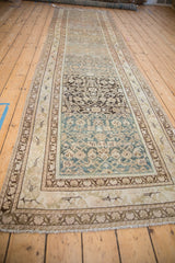 Distressed Malayer runner showcasing geometric Herati design with teal and olive abrashes, bordered by curvilinear blossoms.