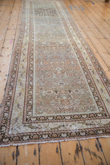 Fringe and patterned borders of the distressed antique Malayer runner, showing dusty green and teal tones.