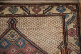 Floral blossom and serrated leaf border of an antique Persian rug with a detailed lattice field.