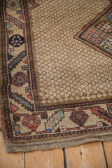 Corner detail of a Northwest Persian rug with a serrated leaf border and ivory lattice field.