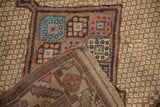 Corner detail of an antique Persian rug, folded to show the hand-knotted face and woven kelim end.