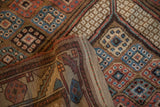 Folded corner of an antique Persian rug revealing its hand-knotted structure and woven foundation.