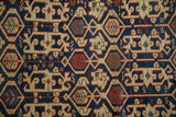 Detailed view of antique Caucasian rug's geometric Koneghand pattern with navy, sand, and madder red.