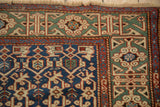 Antique Caucasian rug corner detail, highlighting jade green Kufic border, madder red serpent minor, and navy field.