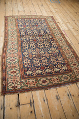 Antique Caucasian rug: Jade green Kufic border, serpent motif, and navy Koneghand field.