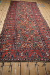 Curvilinear paisley boteh main border and sprawling floral field of antique Northwest Persian runner.