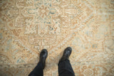 Evenly worn pile of a vintage Heriz rug with geometric patterns in cream, brown, and blue.