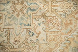 Close-up of the even wear on a distressed Heriz rug with blue and brown patterns.