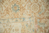 Classic turtle samovar border in dusty blue and brown on a textured, distressed Heriz carpet.