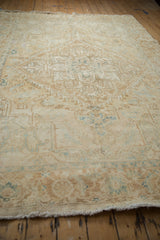 Low angle perspective showing the distressed texture and muted colors of a vintage Persian Heriz carpet.