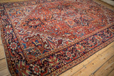Low angle perspective highlighting the geometric design and texture of a vintage Heriz carpet.