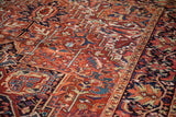 Angled view of a vintage Heriz carpet highlighting its bold geometric patterns and dense, hand-knotted pile.