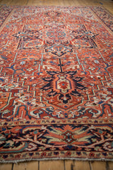 Low angle perspective showcasing the geometric medallion and dense, low pile of a vintage Heriz carpet.