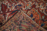 Folded corner of a vintage Heriz carpet revealing its hand-knotted back and wool pile.