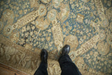 Close-up of a vintage Kurdish carpet's distressed texture and geometric pattern underfoot for scale.