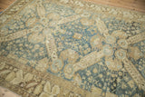 Angled view of the distressed vintage Kurdish carpet's geometric medallions in beige and dusty blue.