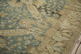 Worn, low-pile texture of a Kurdish carpet with dusty blue and sand Caucasian design motifs.