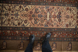 Evenly worn low pile and wide camel main border of an antique Persian Serab runner.