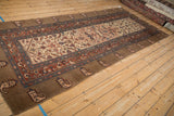 A full perspective view of the antique Serab runner highlighting its wide camel colored border.