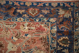 Corner detail of a distressed Lilihan carpet with floral palmettes in the navy border against a copper field.