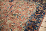 The intricate floral patterns and even wear of a distressed Lilihan's copper and navy pile.