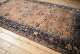 Richly detailed navy border and copper floral field on a distressed antique Lilihan carpet.