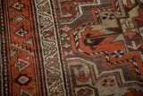 Detail of the serrated vine border and low wool pile on a vintage Kurdish runner rug.