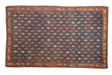 Distressed antique Kurdish carpet with a trellis of diamond panels containing boteh and floral motifs on a blue ground.