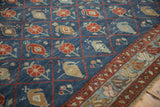 Corner view of an antique Kurdish carpet with a floral trellis field and meandering blossom border.