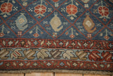 Close-up of the diamond trellis field and meandering blossom border of an antique Kurdish carpet.