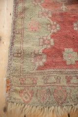 Tattered fringe and restored side cord selvage on an antique, hand-knotted Oushak rug mat.