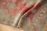 Time-softened pile of an antique Turkish Oushak showing knot heads in ruby and seafoam green.