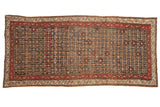 Antique Qashqai runner with a repeating floral design, madder red border, and a time-softened patina.