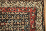 Close-up of the antique Qashqai runner's corner, detailing the hand-knotted weave and floral borders.