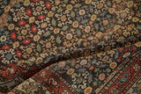 Detail of the low, even pile on an antique Lori Qashqai rug with dense, repeating floral designs.