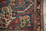 Close-up of a Persian Baktiari rug corner with a multicolored floral border and even, low pile.