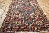 Angled view of a vintage Baktiari rug's complex starburst medallion and colorful floral field.