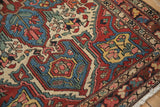 Corner view of a vintage Baktiari rug, highlighting the even wear on its colorful floral motifs.
