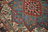 Evenly worn hand-knotted pile on a Baktiari rug with red, blue, and ivory geometric floral details.