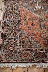 Distressed Hamadan runner's side border, rust and silver floral field patterns, with ivory fringe.