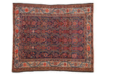 Antique Malayer Persian carpet with scrolling vined medallions in red and orange tones over a deep indigo blue field.