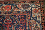 Corner view of an antique Malayer carpet highlighting its meandering vine blossom and boteh border.