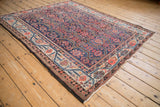 Corner view of a fine antique Malayer carpet showing the geometric field and meandering vine blossom border.