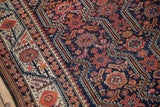 Close-up of the meandering vine and floral border against the cobalt blue field of a fine Persian Malayer carpet.