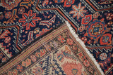 The fine, hand-knotted foundation of an antique Malayer rug revealed beneath its indigo blue pile.