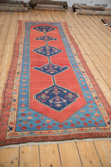 A low angle view of an antique Bakshaish runner showing the textured pile and column of medallions.