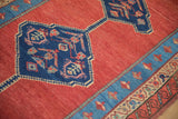 Detail of a Bakshaish rug's blue medallion, abrashed red field, and reciprocating wave design border.