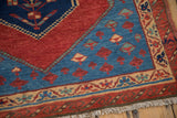A detailed corner view of a Bakshaish rug with wave and vine borders in red and blue.