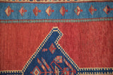 Sapphire blue medallion corner and stylized wave border on the madder red field of an antique Bakshaish.